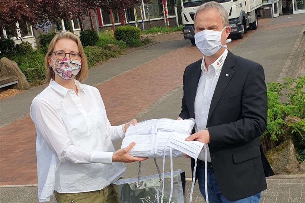 DRK-Blutspende: Kritische Töne und ein phänomenales Spendenergebnis Sabrina Adams-Stenau, Geschäftsführerin SE-Blusen Stenau, übergibt Ralf Rohling, Vorsitzender DRK-Ortsverein, eine Spende von 200 Alltagsmasken aus Baumwolle.