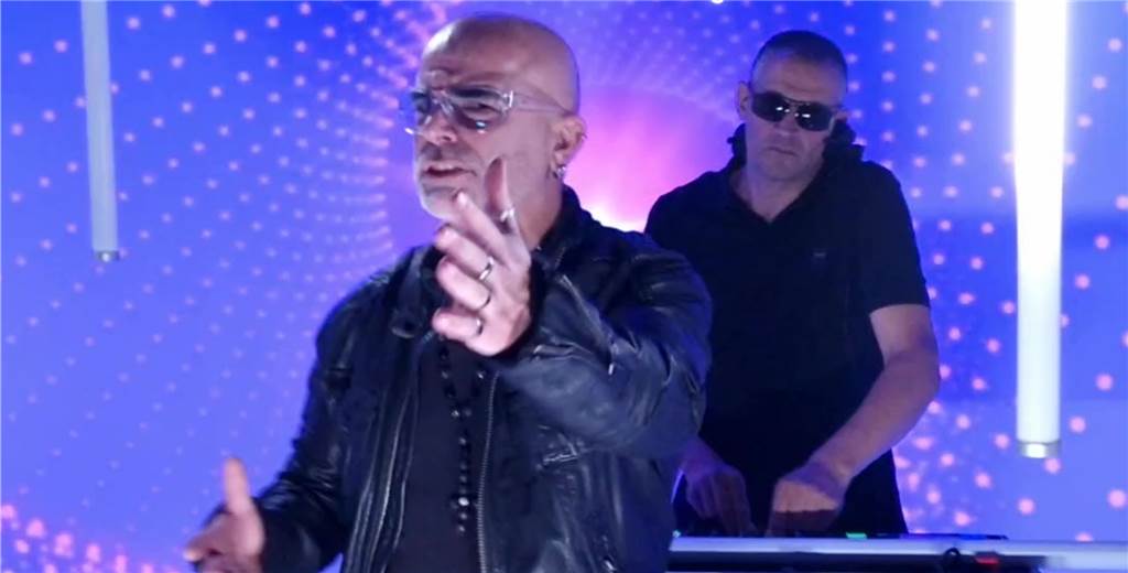 DJ Tom covert bekannten 80er-Hit: „Dieses Mal könnte es richtig krachen“ (mit Video) Leroy Daniels steht vorne und streckt seine Hand aus, dahinter steht DJ Tom an einem DJ-Pult.