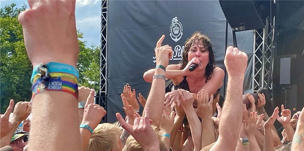 Drei Tage Punk auf der „Wiese“ - viele Fotos vom Ruhrpott Rodeo 2022 Frau sind auf den Händen der Zuschauer liegend