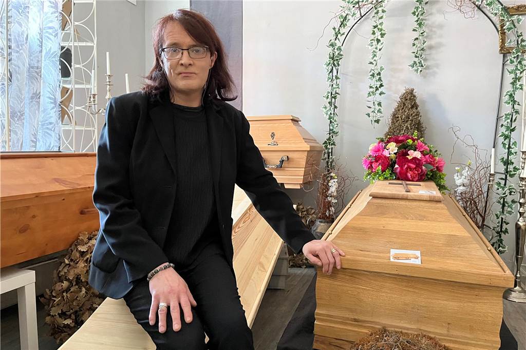 Claudia Pohlhaus sitzt auf einem Sarg
