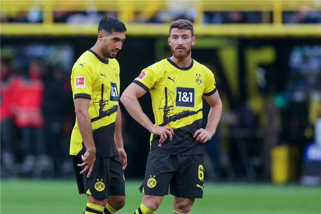 Emre Can und Salih Özcan stehen auf dem Rasen.