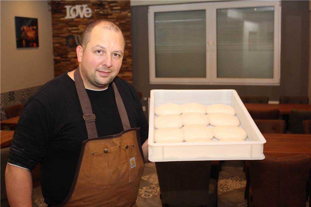 Mit vielen Baumängeln: Wohnung über „Mr. Pizza“ wird zwangsversteigert Salvatore Mandellino, Pizza-Bäcker bei Mr. Pizza auf der Provinzialstraße 218 in Lütgendortmund, hält eine Kiste mit Pizzateig-Rohlingen fest.