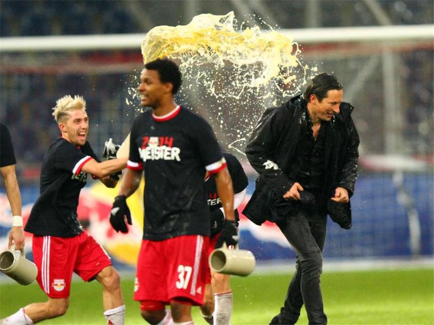 Meister Salzburg will in Europa durchstarten Salzburgs Kevin Kampl (l) überschüttet Trainer Roger Schmidt bei der Meisterfeier mit Bier. Foto: apa