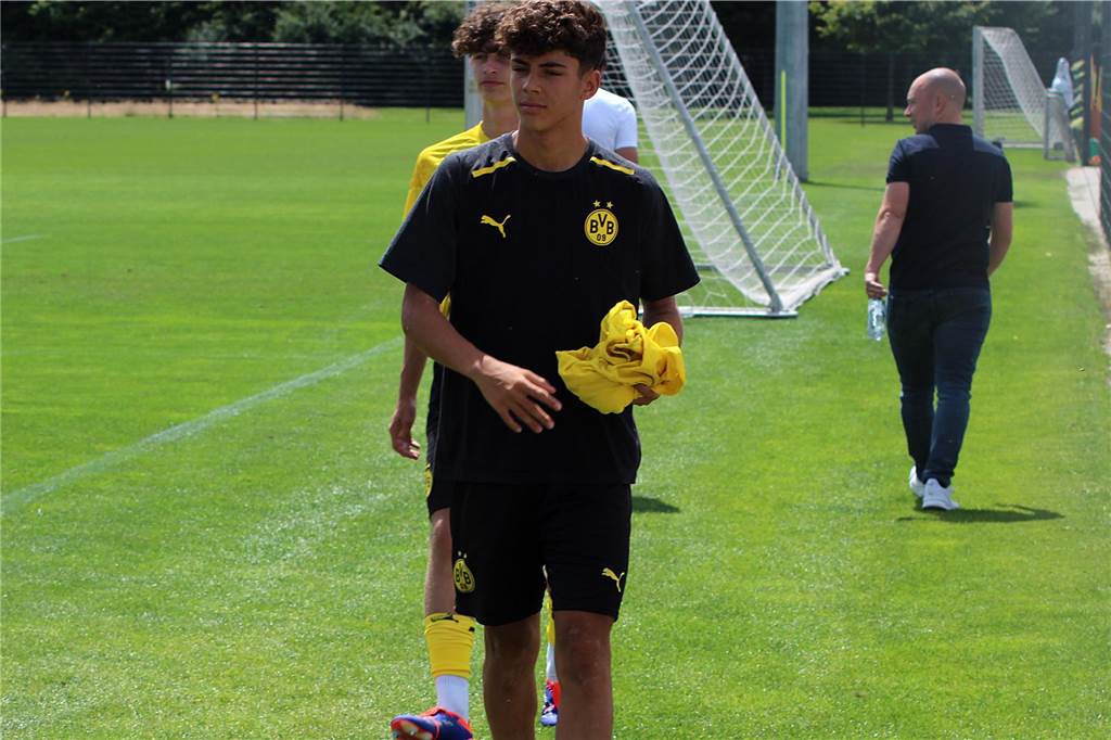 Samuele Inacio macht erste Schritte beim BVB: So plant Dortmund mit dem italienischen Toptalent Samuele Inacio trägt ein T-Shirt in der Hand.