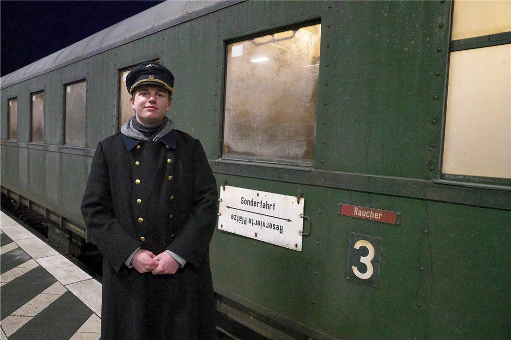 Marion Lochthove und Rainer Uhlich genießen Fahrt im nostalgischen Zug Ein Schaffner in nostalgischer Kleidung steht vor dem Zug.