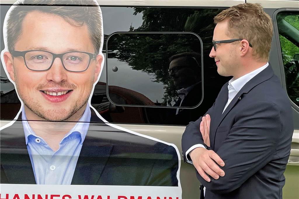 Kandidaten-Porträt: Der jugendliche Johannes und der Wahlkämpfer Waldmann Schau mir in die Augen, Kleiner. Waldmann vor seinem Konterfei auf dem Wahlkampf-Mobil.