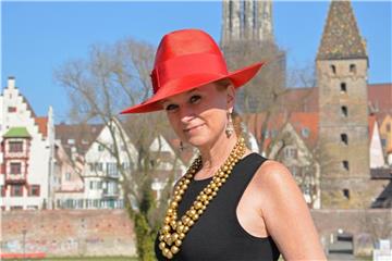 Schick angezogen und trotzdem Flagge zeigen: Personal Shopperin Sonja Grau trägt ein schwarzes Kleid zu rotem Hut und goldener Kette. Foto: Jasmin Grau