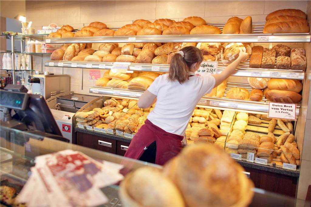 Nach Schickentanz-Insolvenz: Ex-Mitarbeiterinnen beklagen Missstände Eine Verkäuferin arbeitet in einer Filiale eines Backhauses. Sie greift zu einem Brot. Hintergrund ist die Insolvenz des Unternehmens Schickentanz aus Dortmund.