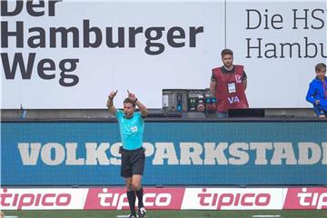 Schiedsricher Felix Brych zeigt einen Videobeweis an. Foto: Axel Heimken