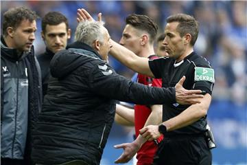Schiedsrichter Tobias Stieler (r) diskutiert heftig mit Freiburgs Trainer Christian Streich. Foto: Ina Fassbender