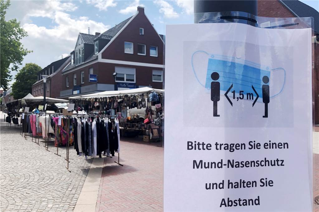 Erster Krammarkt in Stadtlohn nach Coronapause findet geteiltes Echo Schilder mahnen die Krammarktbesucher, die Abstandsregeln einzuhalten und Atemschutzmasken aufzusetzen.