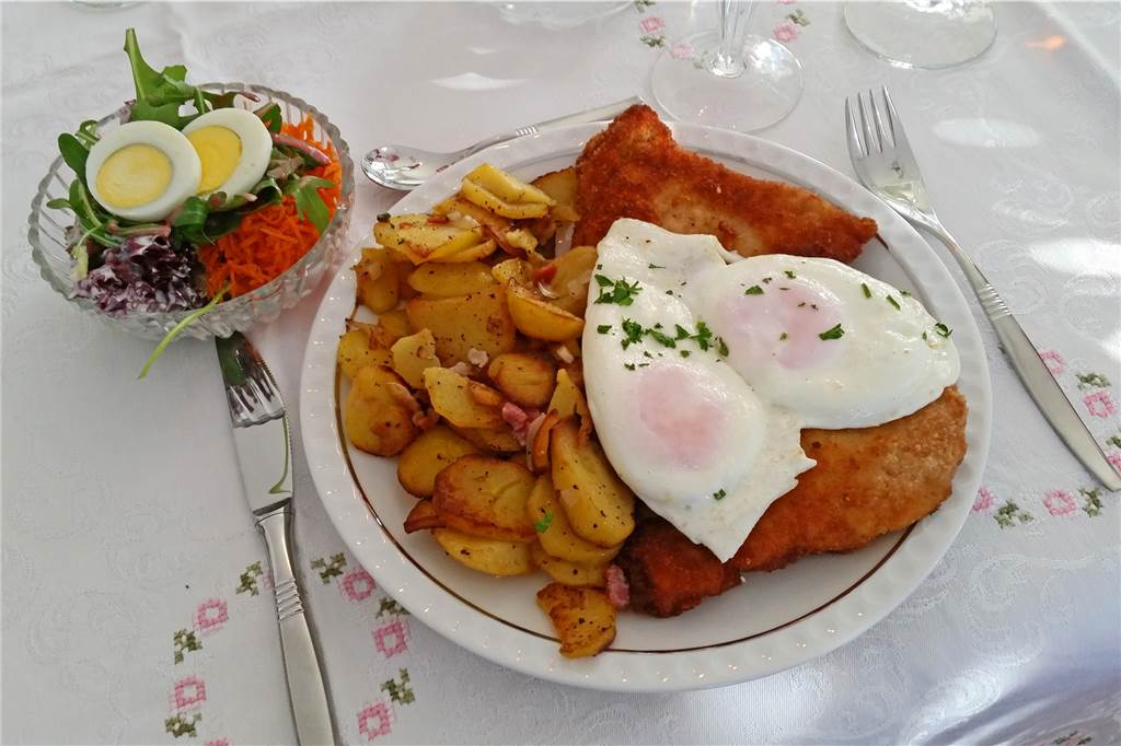 Gasthaus Schwering: Alte Traditionen und frische Ideen aus Dömern Schnitzel mit Bratkartoffeln und Spiegelei, dazu Salat.