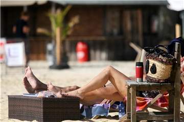 Schöner Spätsommer: Besucher des Freibades am Baldeneysee in Essen nehmen ein Sonnenbad. Foto: Roland Weihrauch