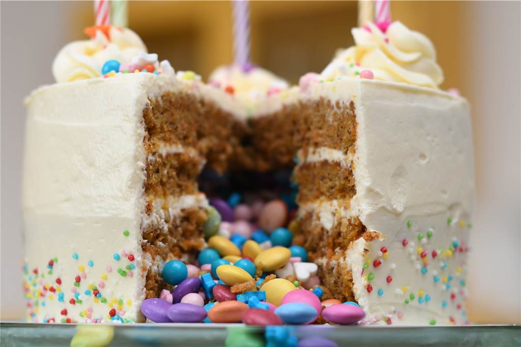 Angeschnittener Pinata Kuchen mit Schokolinsen und Zuckerstreuseln.