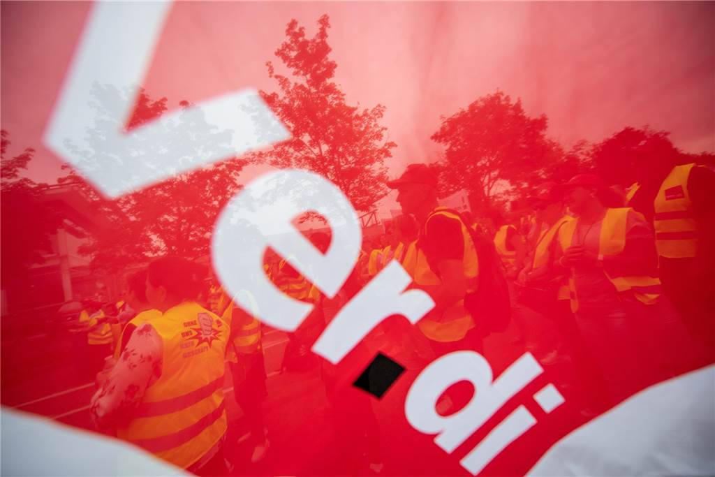 Kunden bemerken Streik in der Mengeder Kaufland-Filiale nicht Durchsichtige Fahne der Gewerkschaft Verdi. Im Hintergrund Kaufland-Mitarbeiter in gelben Streikwesten.