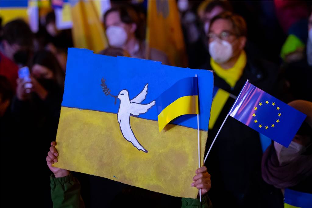 Ukrainer in Oer-Erkenschwick: „Wir haben vor der russischen Armee keine Angst“ Menschen halten eine Ukraine-Flagge hoch.