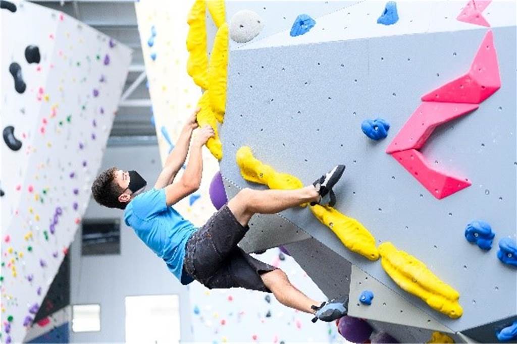 Mehr Bewegung: 7 ungewöhnliche Sportarten zum Ausprobieren mann klettert eine boulderwand hoch