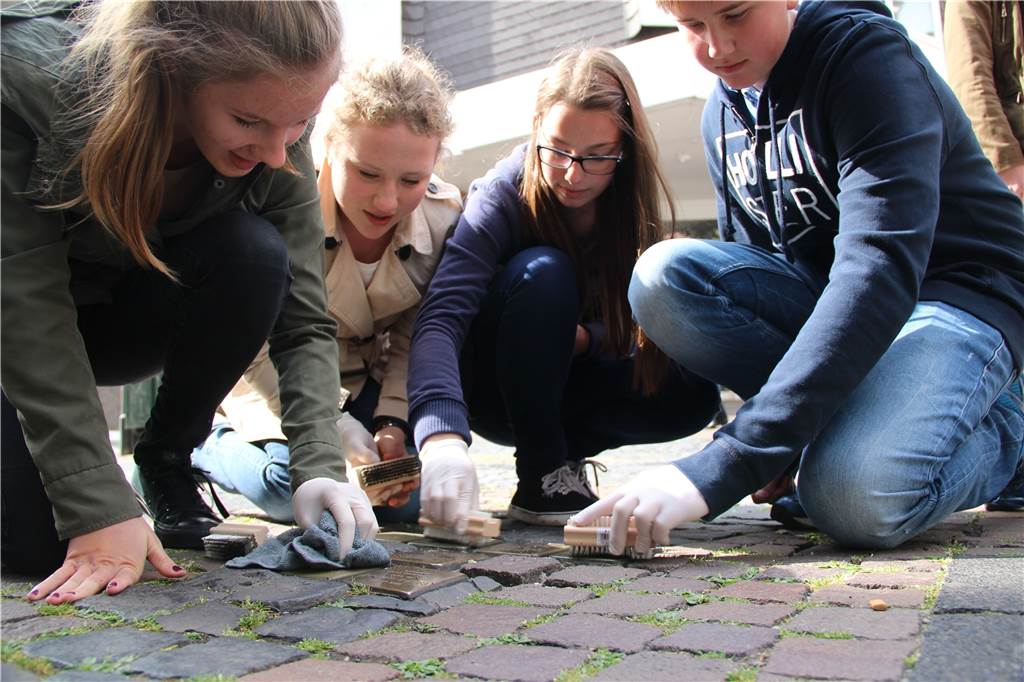 Schüler bei der Pflege der Stolpersteinpflege in der Werner Altstadt