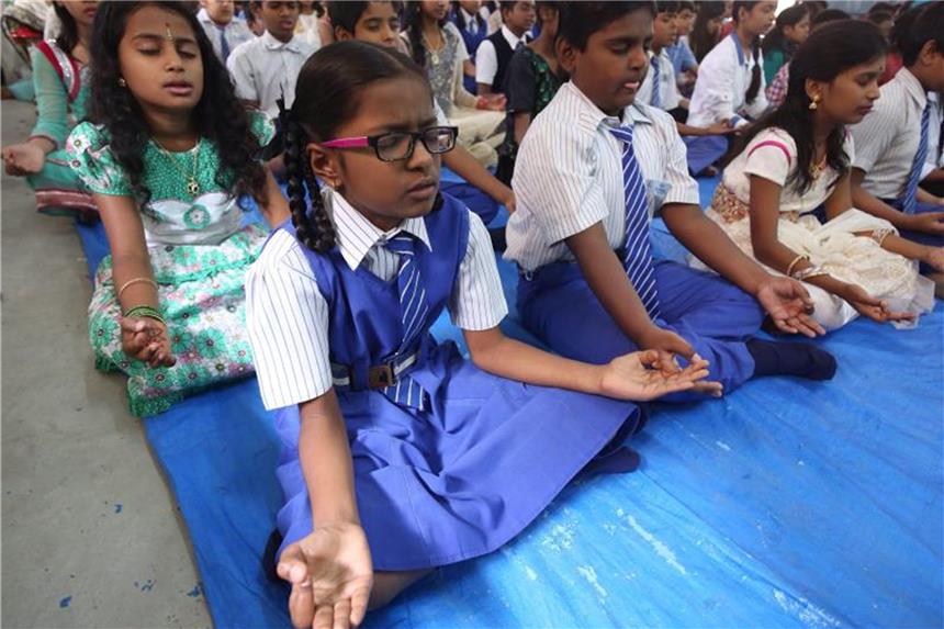 Glücksunterricht in Dehli: Dalai Lama stellt Lehrplan vor Schüler bei einer Yoga-Übung. Foto: Jagadeesh Nv/EPA