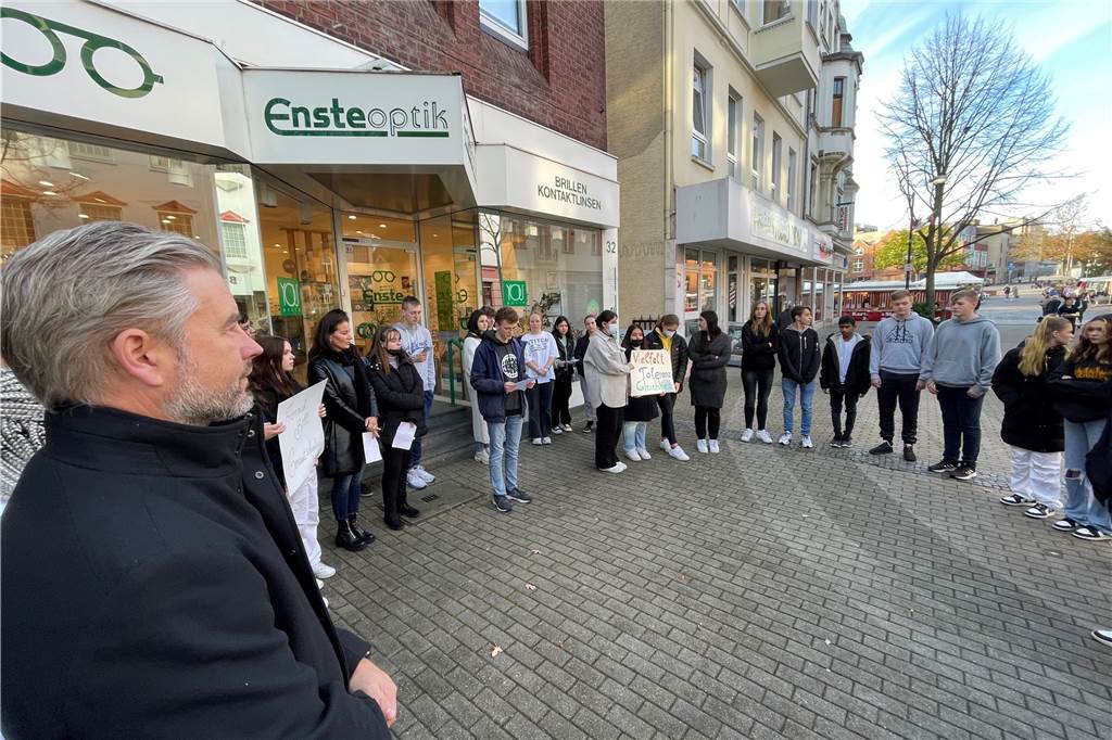 Schüler und Schülerinnen der Heinrich-Böll-Gesamtschule versammelten sich mit ihrem Schulleiter Tobias Schnitker rund um einen Stolperstein, um der ermordeten Juden zu gedenken.