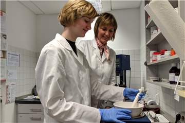 Schülerin Frieda testet das Anrühren auf dem Wasserbad mit Apothekerin Anke Vöcking.