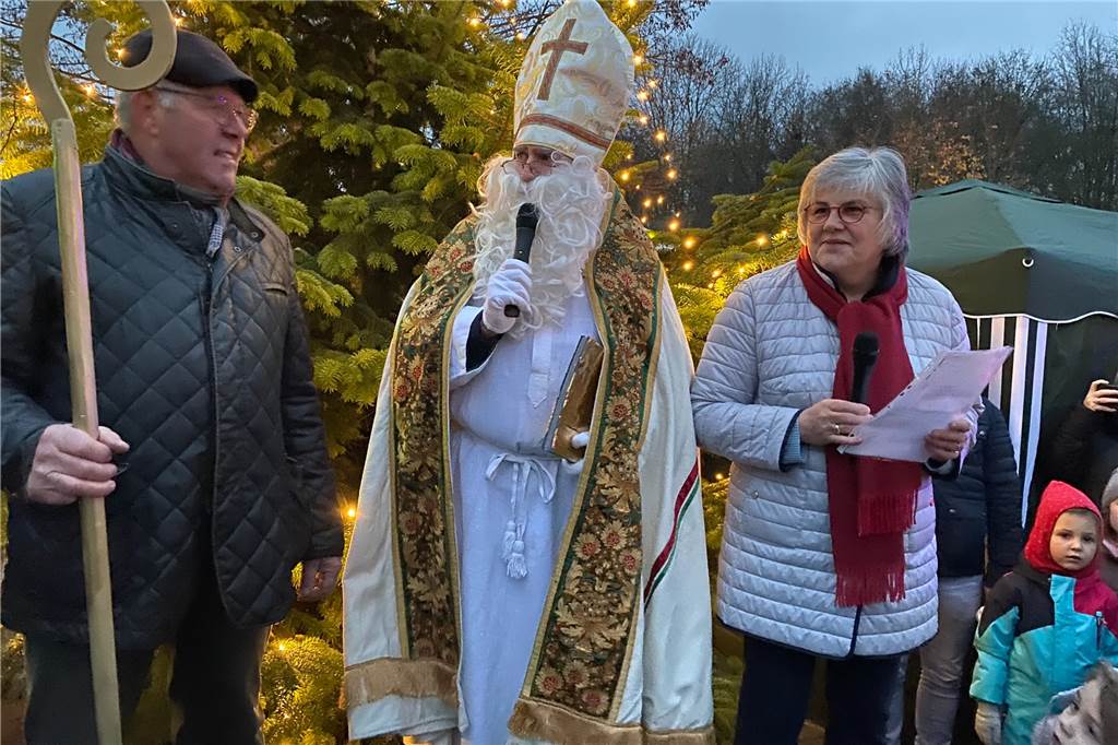 Schützen-Chef Egbert Ortmann, Nikolaus Christoph Bargel und Organisatorin Marika Holz bei der Verteilung der Tüten auf dem Adventsmarkt Langern.
