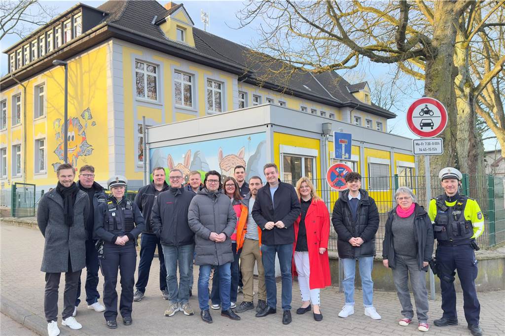 Schulleiter Peter Pyka (l.), die Polizei, Achim Waldert (Verkehr) und Thomas Thiel (Ordnung) aus dem Rathaus, Politiker verschiedener Parteien und weitere Beteiligte freuen sich über die Sperrung des Hangwegs zu Bring- und Abholzeiten an der Wilhelmschule.