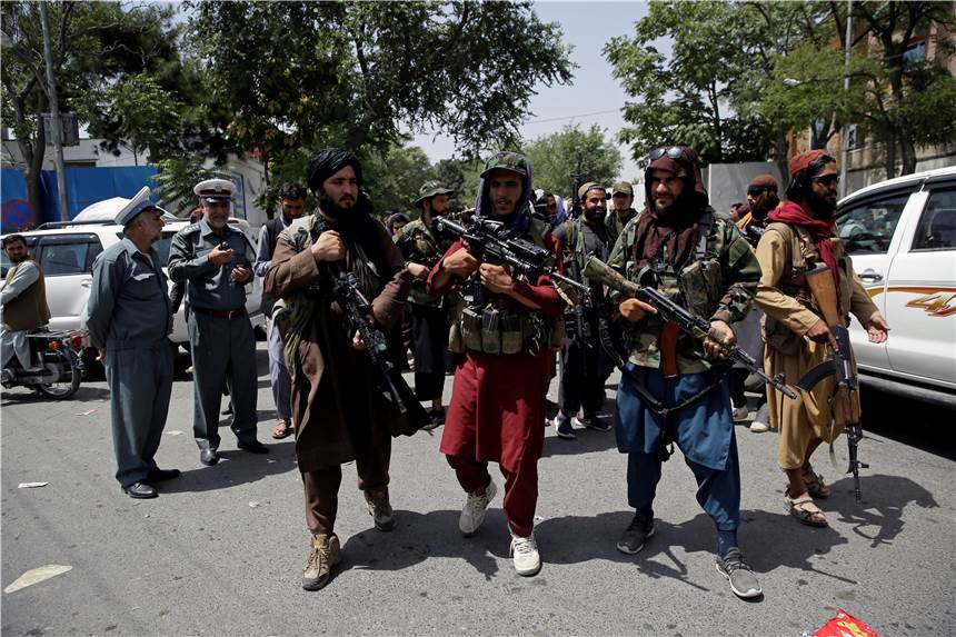 Taliban erbeuten biometrische Geräte: Tickende Zeitbombe für Ortskräfte Schwer bewaffnete Taliban-Kämpfer patrouillieren vor zwei Verkehrspolizisten.