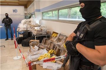 Schwer bewaffnete und vermummte Polizeibeamte bewachen im bayerischen Landeskriminalamt etwa 640 Kilo Kokain, Waffen und Bargeld. Foto: Peter Kneffel