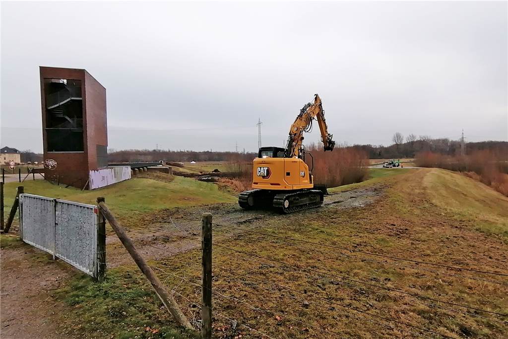 Emscher-Auen: Nach Ausbau Platz für sieben Millionen Badewannen Wasser Bagger auf einem Damm in den Emscher-Auen. Links daneben ein Aussichtsturm am Stauwehr.