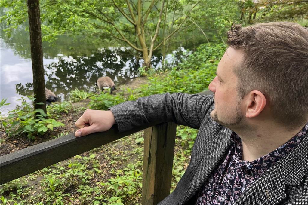 Der bundesweite Spitzenkandidat der Tierschutzpartei für die Europawahl 2024, Sebastian Everding, hockt vor dem Teich im Rombergpark in seiner Heimatstadt Dortmund.