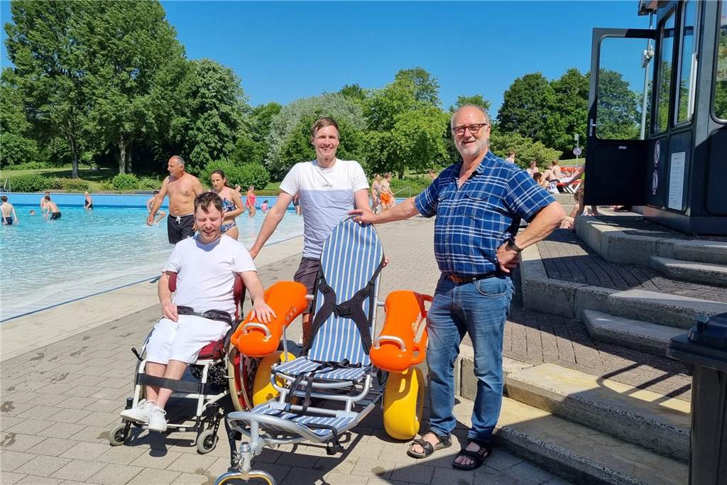 Nordkap-Tour: Sebastian Knobloch (33) spendet Baderollstuhl an Aquahaus Sebastian Knobloch (M.) mit seinem Kumpel Michi bei der Übergabe des Baderollstuhls an Franz-Josef Bülter, den Leiter des Kombibads Aquahaus.
