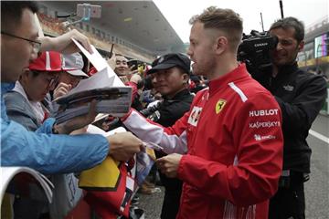 Sebastian Vettel gibt am Streckenrand in Shanghai seinen Fans Autogramme. Foto: Andy Wong/AP