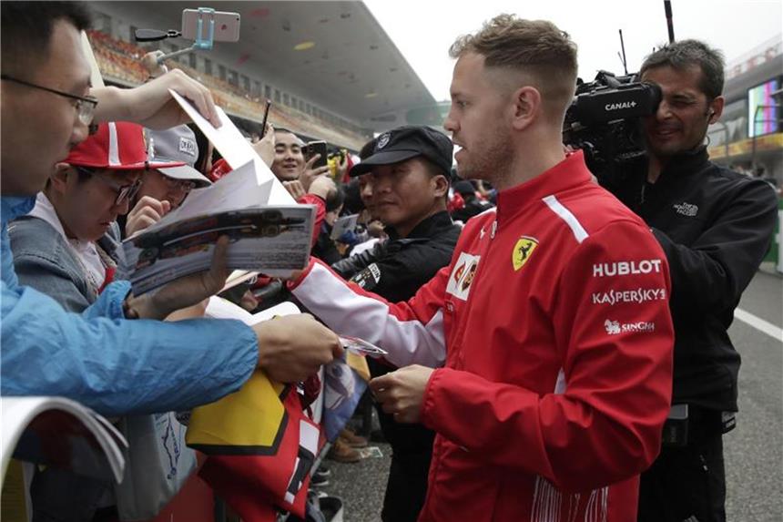 Sieg-Statistik interessiert Vettel nicht: „Sehr langer Weg“ Sebastian Vettel gibt am Streckenrand in Shanghai seinen Fans Autogramme. Foto: Andy Wong/AP