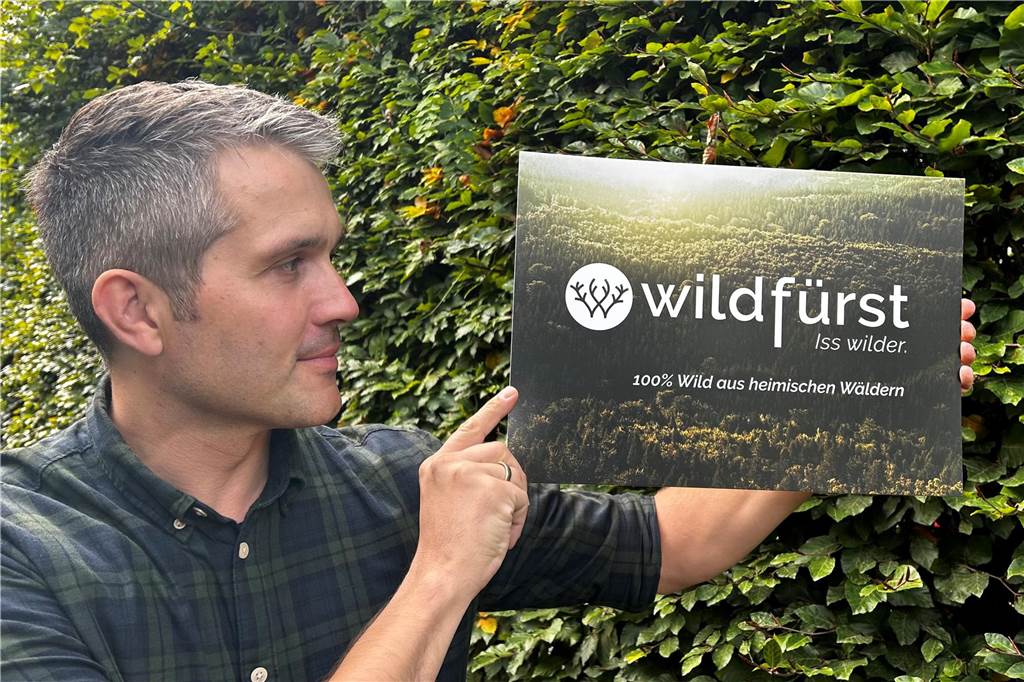 Christoph Ekamp (41) verspricht nachhaltigen Genuss mit „Wildfürst“ Christoph Ekamp hält ein Schild, auf dem "Wildfürst" steht.