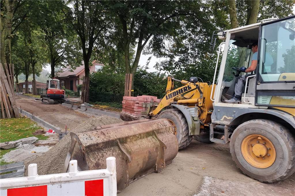 Wut über Endausbau: Zwei Anlieger sollen fast 40.000 Euro zahlen Ein Frontlader bringt Steine zur Baustelle