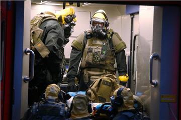 SEK-Beamten mit Atemschutzmasken und Schutzanzügen stehen in einem Fahrzeug vor einem Wohnkomplex. Der in Köln verhaftete Tunesier soll seine Vorbereitungen für einen Terroranschlag mit hochgiftigem Rizin bereits weitgehend abgeschlossen haben, als die Polizei zuschlug. Foto. David Young Foto: David Young