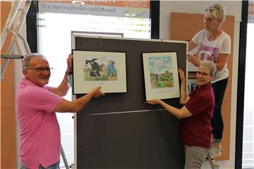 Sie bereiten die Karikaturenausstellung der Hospizgruppe Selm-Olfen-Nordkirchen  vor: (v.l.) Dieter Niechcial (2. Vorsitzender) Dr. Antje Münzenmaier (Vorsitzende und Dorothea Stockmann (Koordinatorin).