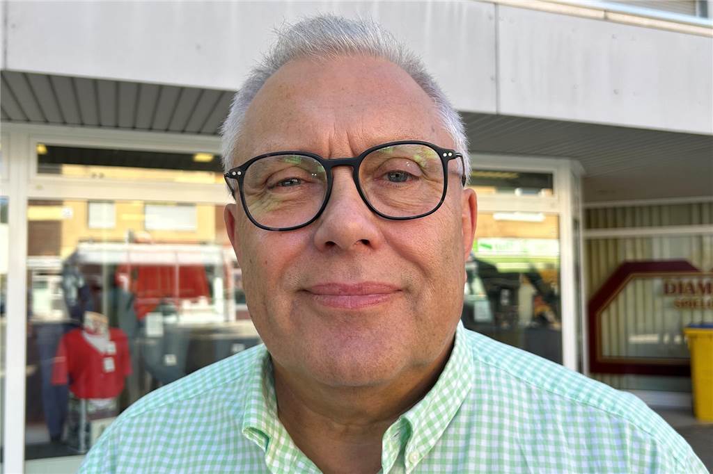 Trotz sinkender Immobilienpreise: Neubau kann sich kaum jemand leisten
Porträt von Immobilienmakler Volker Meyer. Er trägt kurze, graue Haare und eine Brille. Er hat ein türkis-weiß-kariertes Hemd an und steht vor einer Hausfassade.