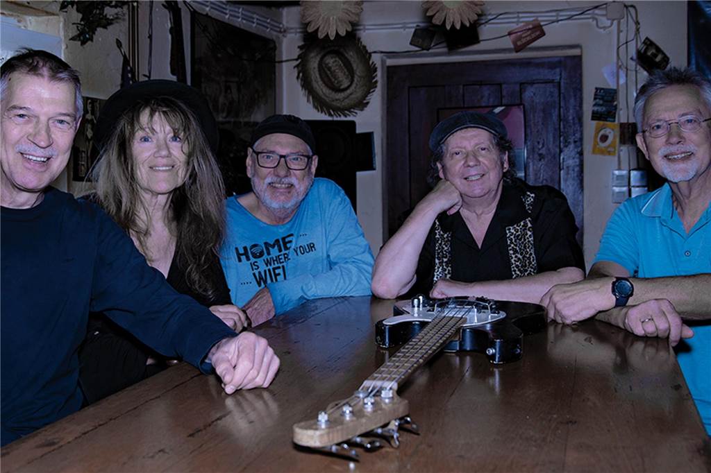 Sie sind T’s Bluesfriends: (v.l.) Werner Oskamp, Rita van Nek, Thomas Waßkönig, Udo Dinkelbach und Gerhard Treutler sitzen an einem Tisch, auf dem eine Gitarre liegt.