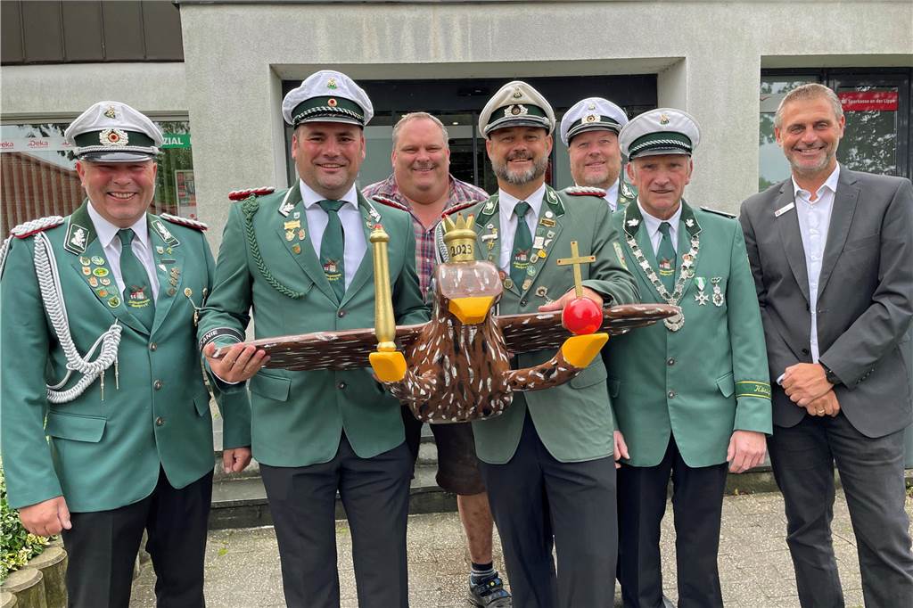 Schützenverein Baaken kehrt mit Fest zu seinen Wurzeln zurück Sieben Mann haben einen Vogel. (V. l.) Vorsitzender Thomas Behrendt, Geschäftsführer Marius Sendermann, Vogelbauer Stefan Hoselmann, 2. Vors. Daniel Krause, Oberst Jörg Kortenstedde, König Ludwig Marckhoff und Sparkassen-Filialleiter Jörg Lütkemeier.