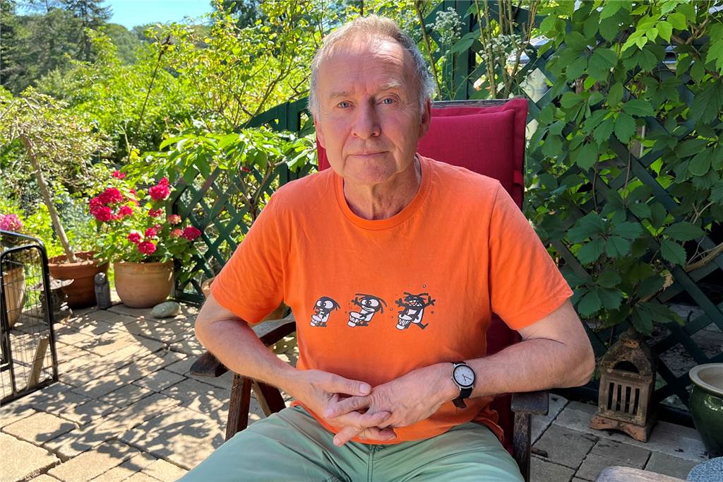 Bernd Witte sitzt in seinem Garten.