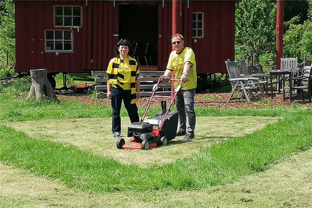 Vogelwiese mit BVB-Logo: Oestricher träumt von Rasenmähen und Meisterschaft Silke Wunsch und Gerald Barthen mit einem Rasenmäher auf der Gemeinschaftswiese am Erlenkamp in Dortmund-Oetrich.
