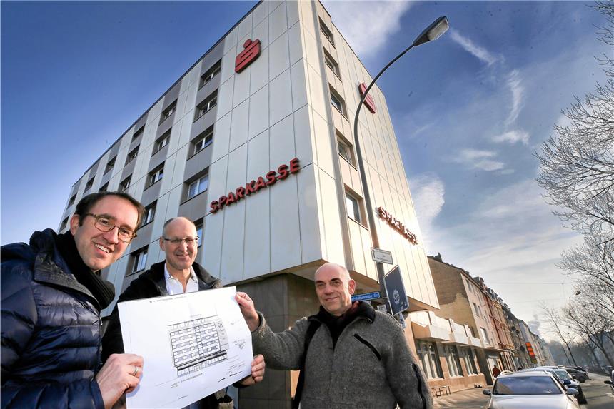 Bald sollen Kinder im alten Sparkassengebäude toben Sind von ihrem gemeinsamen Projekt überzeugt und freuen sich auf den Beginn der Arbeiten: (v.l.) Architekt Christoph Helbich, Hauseigentümer Christian Schmitt und Veit Hohfeld vom Verein Stadtteil-Schule. Die Grafik zeigt das ursprüngliche Gebäude aus den 1960er Jahren.