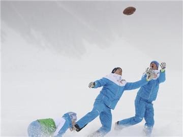 Skisportler vertreiben sich die Wartezeit in Lake Louise mit Rugby im Tiefschnee. Foto: Mike Sturk