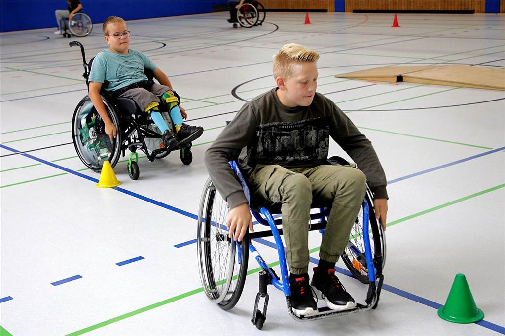 Hauptschüler lernen das „Rollstuhlgefühl“ kennen Slalomparcours mit dem Rollstuhl. Für Paul (hinten) kein Problem, für seine Mitschüler gewöhnungsbedürftig.