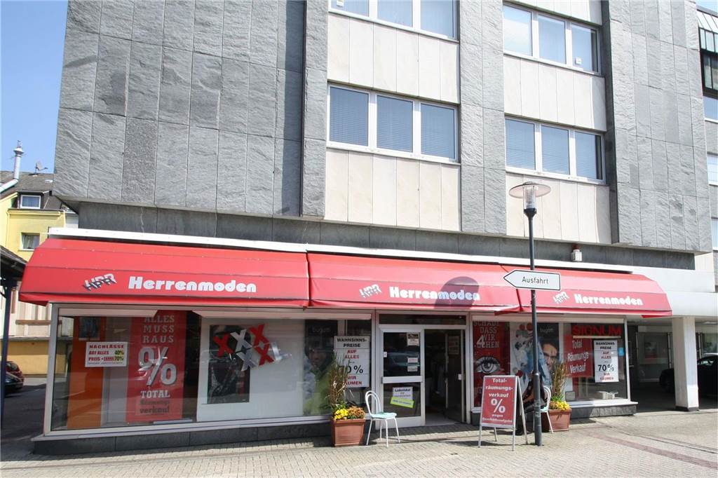 Altes Ladenlokal am Marktplatz mit rotem Vordach über den vorderen Schaufensterscheiben. 