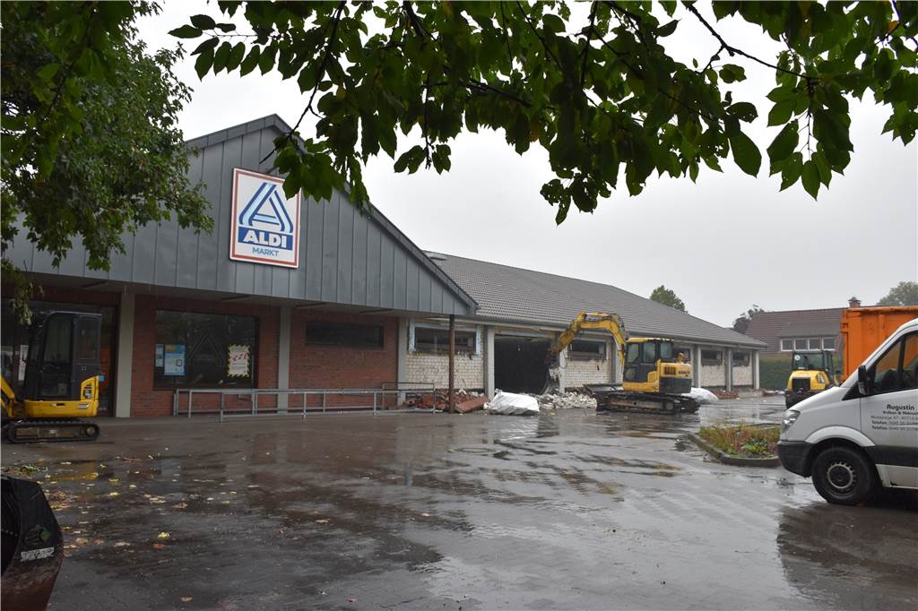Nach Neubau: Aldi beteuert Bauversprechen, Anwohner verhalten froh Ein Supermarkt wird abgerissen von einem Bagger