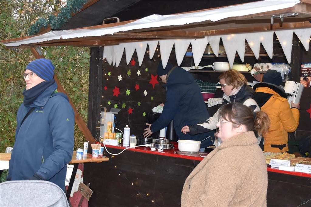 Menschen feiern auf dem Weihnachtsmarkt auf Hof Lenz in Ascheberg 2024.