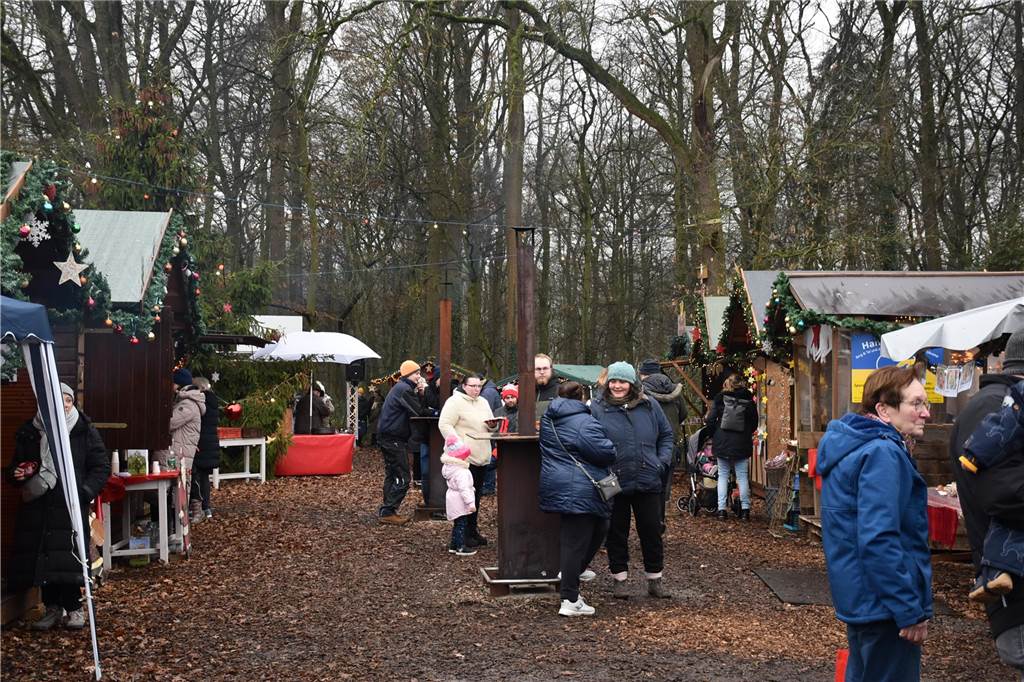 Menschen feiern auf dem Weihnachtsmarkt auf Hof Lenz in Ascheberg 2024.